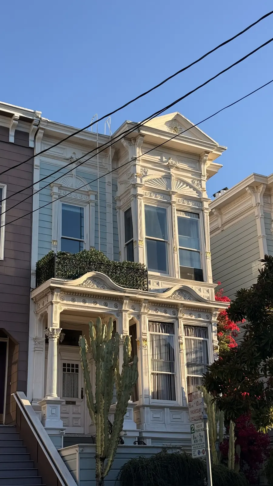 Cream-colored house with ornate trim and stacked bay windows